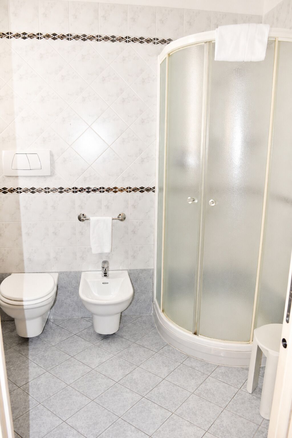 Ein Badezimmer mit Toilette, Bidet und einer Duschkabine.