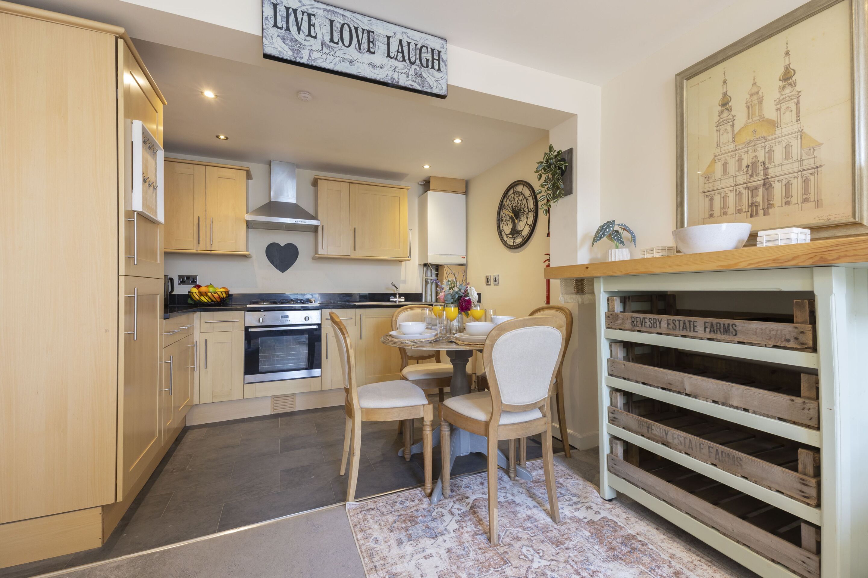 A modern kitchen with wooden cabinets, a stove, and a dining area with chairs and a table.