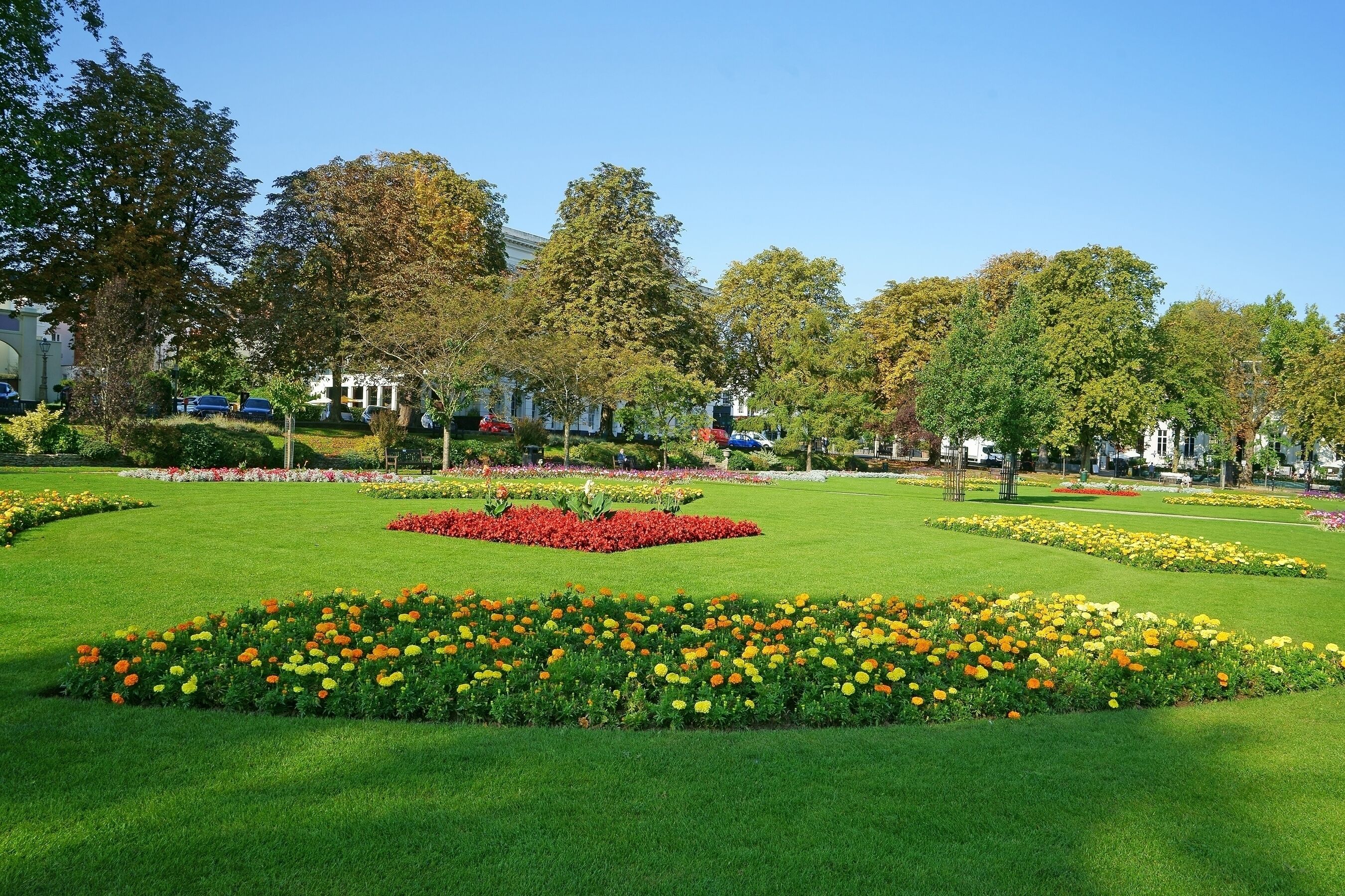 A well-maintained park with manicured lawns and flower beds.