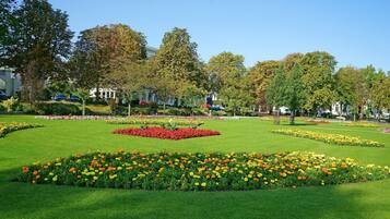 A well-maintained park with manicured lawns and flower beds.