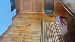 A kitchen with wooden cabinets, a blue refrigerator, a microwave, and a dishwasher. - Convenient Lakeside House (Rangeley)
