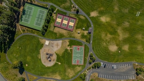 An aerial view of a sports complex with multiple tennis courts, a basketball court, and a parking area. - 1PM In/Out | Play All Day / Soak All Night | GameRoom + Swim Spa (Cle Elum)