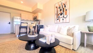 A modern living room with a sofa, a coffee table, and a dining area with chairs. - Couples Private Plunge Pool Retreat Near Beach (Punta Cana)