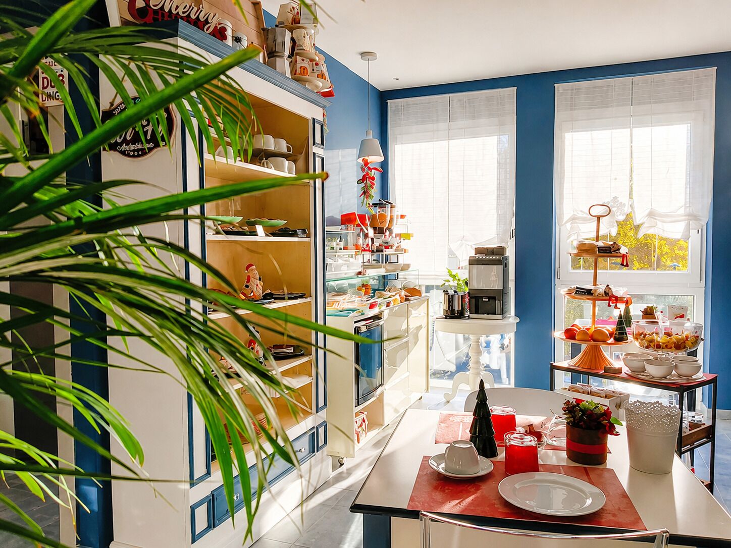 Una cucina con isola centrale, scaffali pieni di utensili da cucina e una finestra con vista.