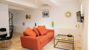 Una sala moderna con un sofá, una mesa de centro y una escalera de caracol.
