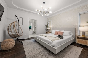A modern bedroom with a large bed, a hanging chair, and a bedside table with a lamp.