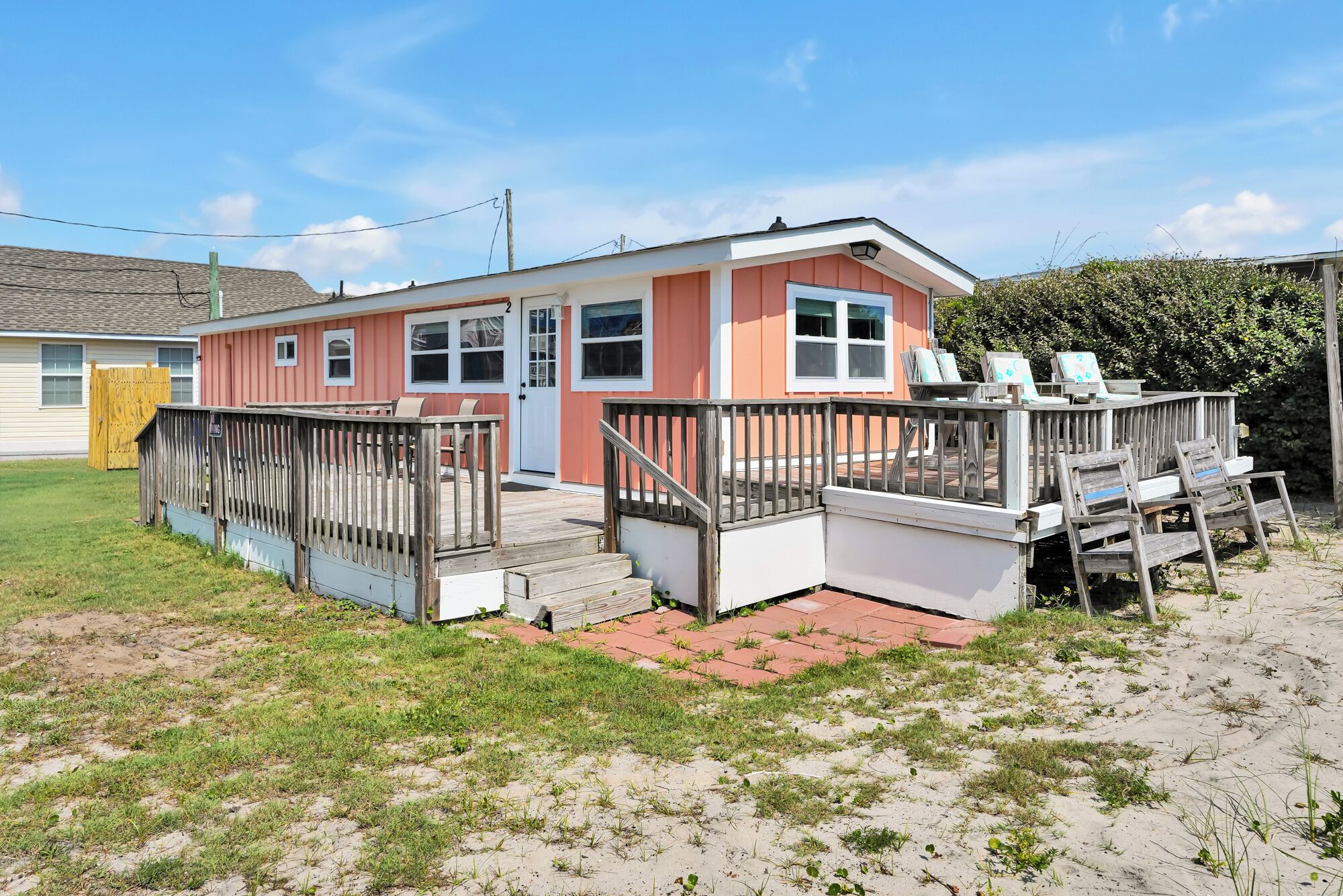 Ein eingeschossiges Haus mit Veranda, Garage und einer kleinen Terrasse.