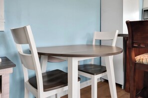 A small round table with two white chairs, one with a dark seat cushion. - Cozy ocean front 3-bedroom cottage in beautiful Carolina Beach (Carolina Beach)