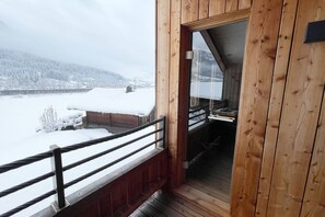 A wooden balcony with a view of a snowy landscape and mountains. - Maria's Alpine Apartment (Brixen im Thale)