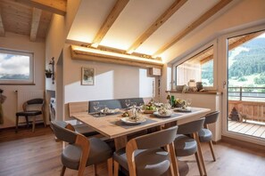Ein Essbereich mit einem Holztisch, gedeckt für vier Personen, umgeben von Stühlen.