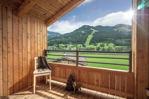 Ein Holzbalkon mit Blick auf eine gebirgige Landschaft.
