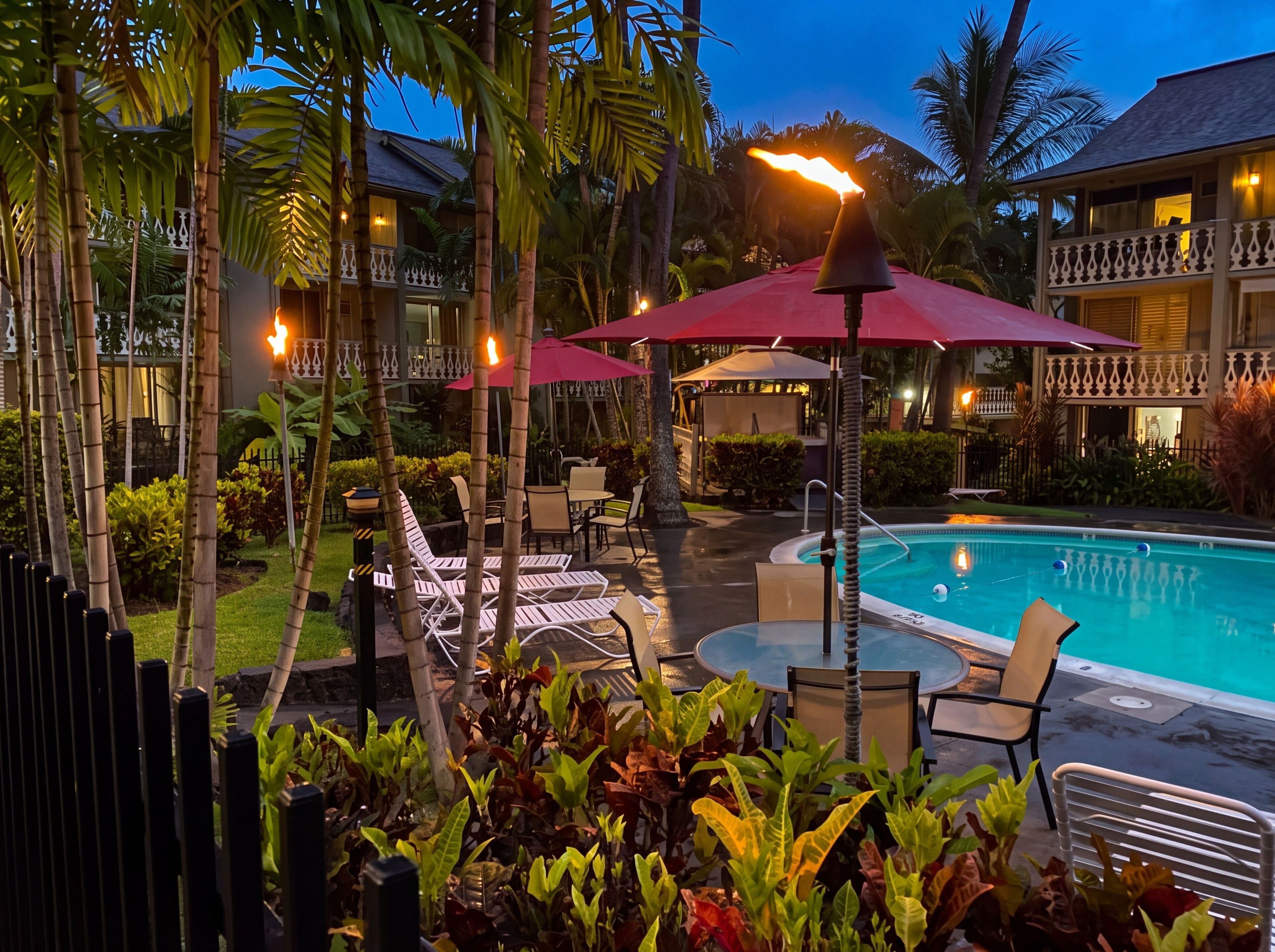 A poolside area with lounge chairs, umbrellas, and a pool.