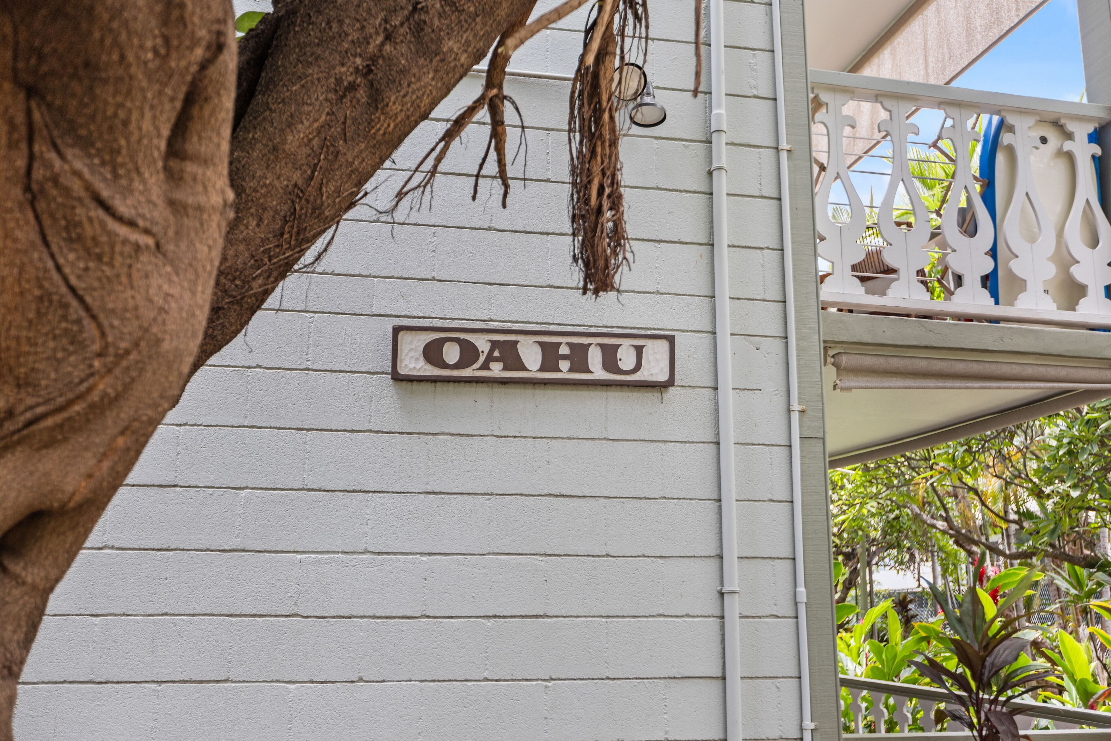 A white building with a sign reading 'OAHU' mounted on the wall.