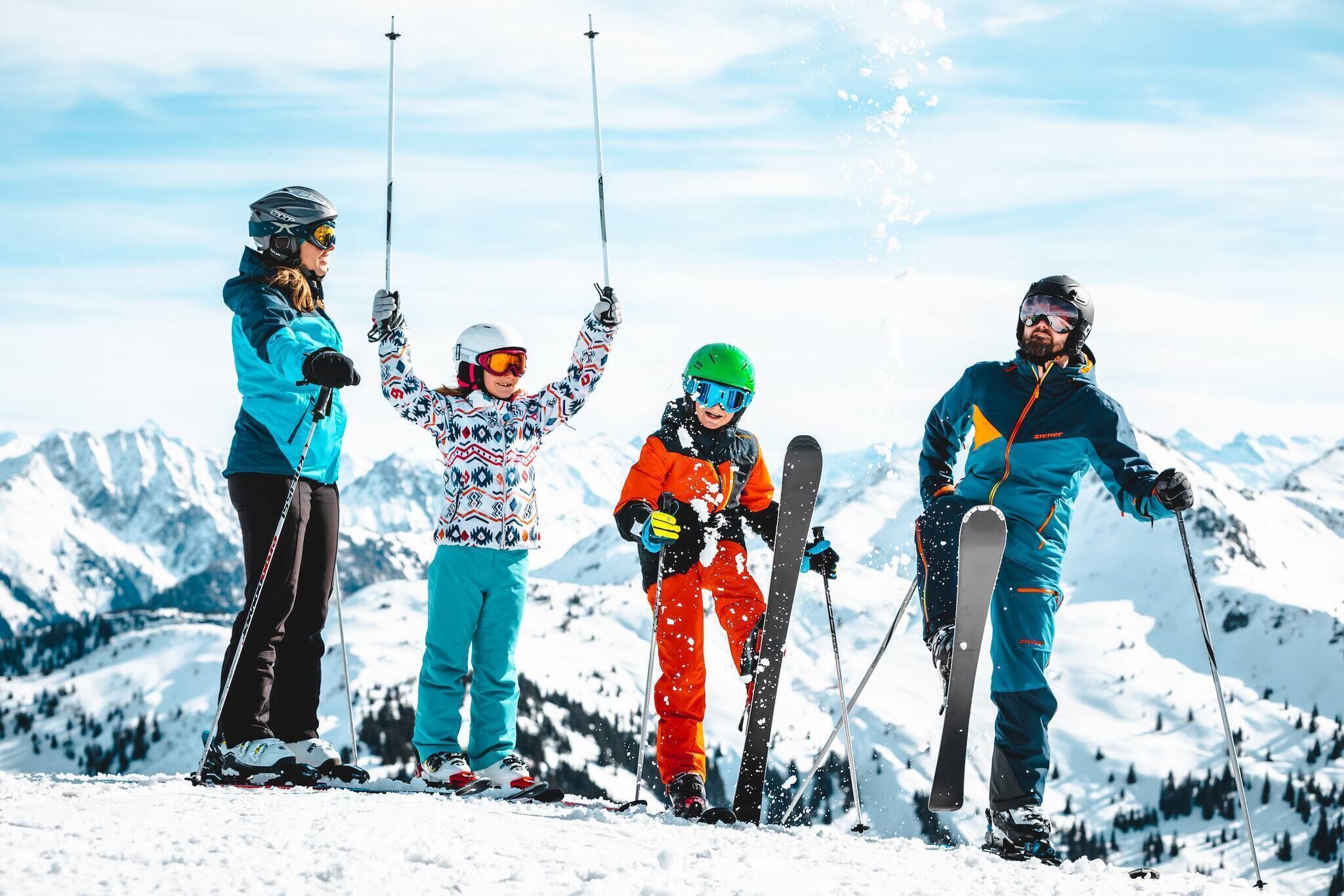 Eine Gruppe von Skifahrern auf einem verschneiten Berg unter blauem Himmel.