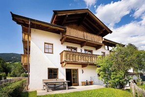 Ein zweistöckiges Holzhaus mit einem Balkon, einem Tisch und Stühlen davor.