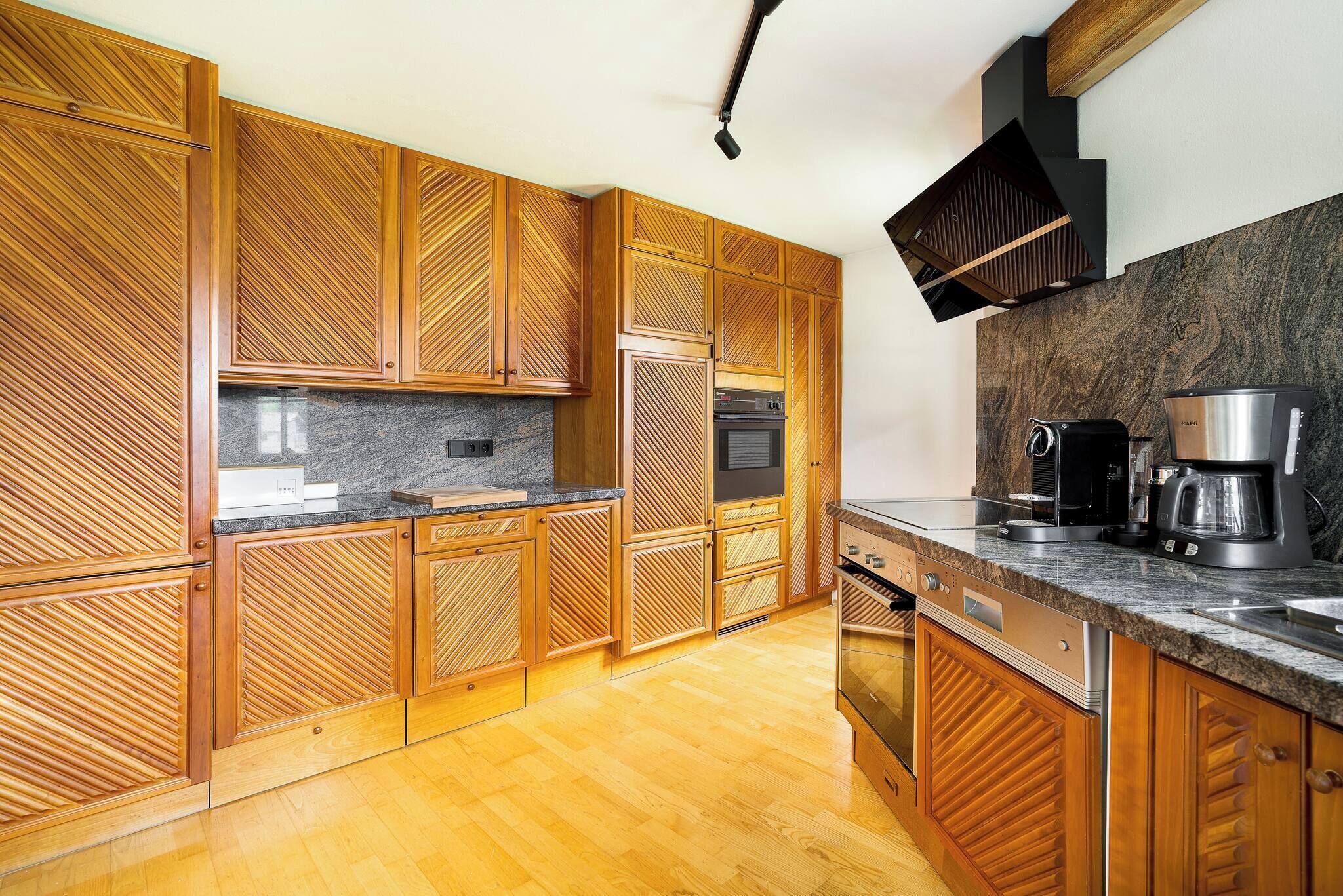 A modern kitchen with wooden cabinetry, a granite countertop, and stainless steel appliances.
