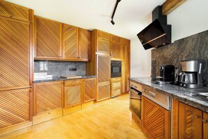 Eine moderne Küche mit Holzschränken, einer Granit-Arbeitsplatte und Edelstahlgeräten.