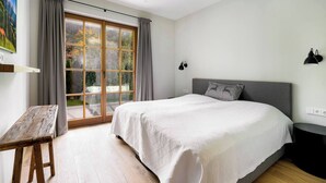 Ein Schlafzimmer mit einem großen Bett, einem Schreibtisch und einem Fenster mit Vorhängen.