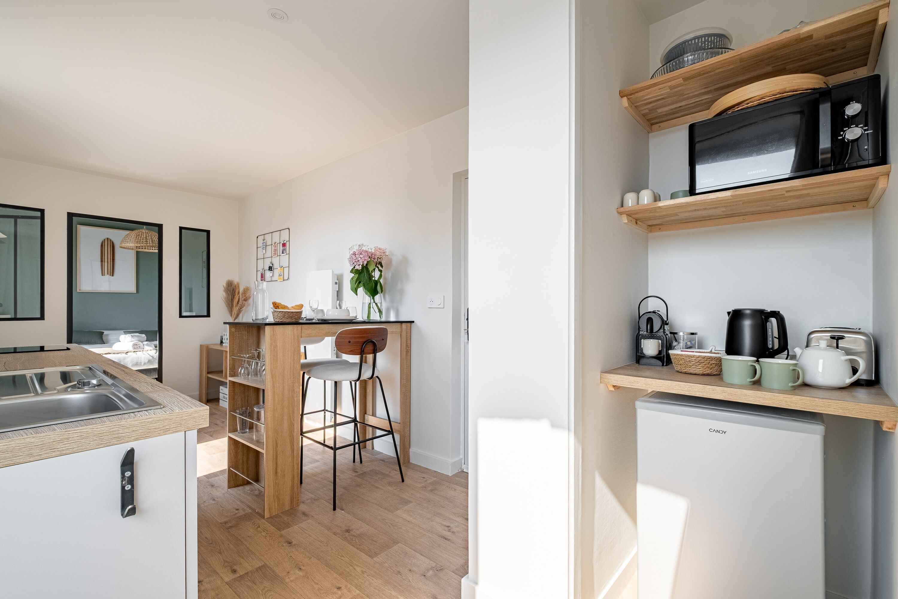 Una cocina moderna con microondas integrado, refrigerador y mostrador de bar de madera.