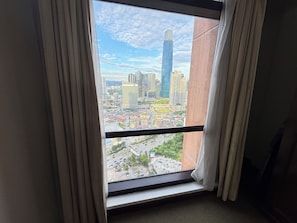 A window with a view of a cityscape, including high-rise buildings and a road. - Times Square By Eas Maju (Kuala Lumpur)