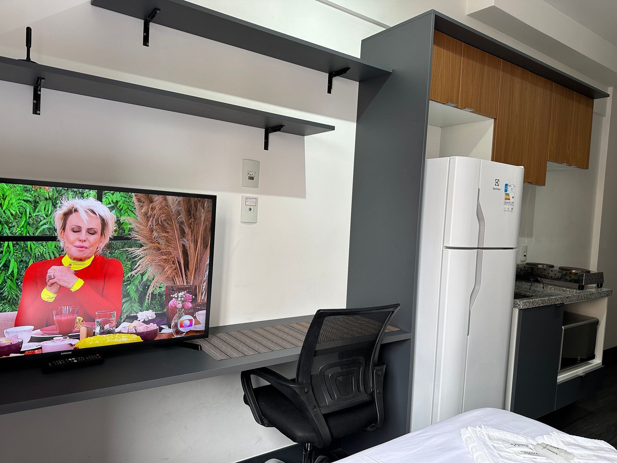 A modern kitchenette with a built-in refrigerator, a microwave, and a stove.