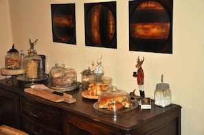 A buffet table with various food items and decorative objects.