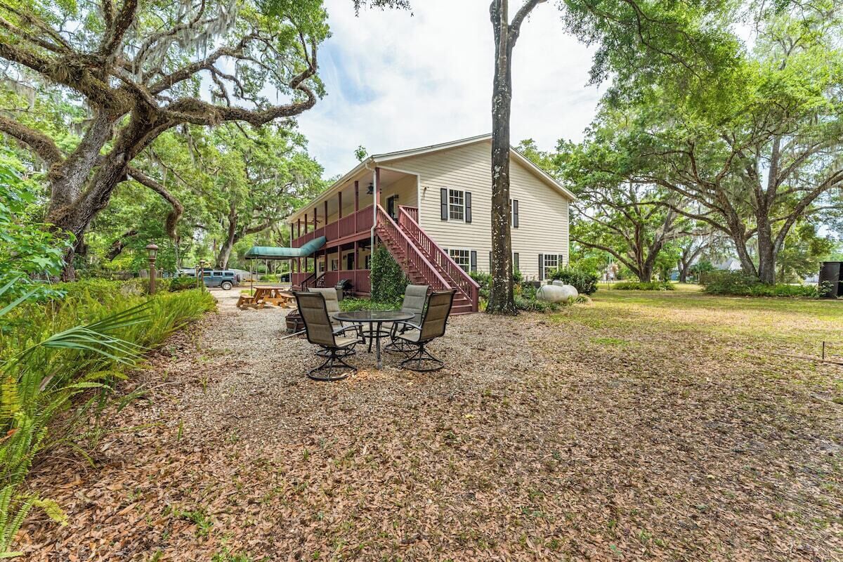 A two-story house with a covered porch, a staircase, and a patio with outdoor furniture.