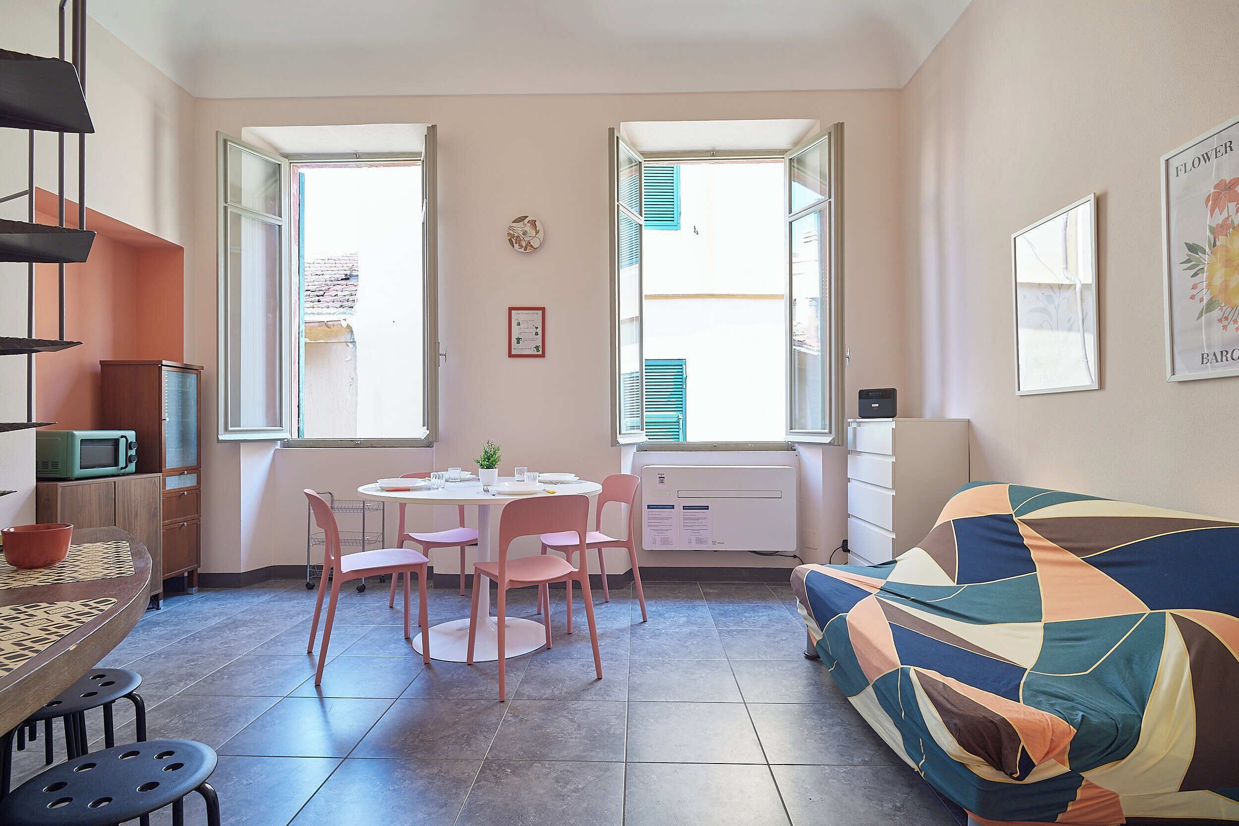 A compact living space with a dining area, a sofa, and a kitchenette.