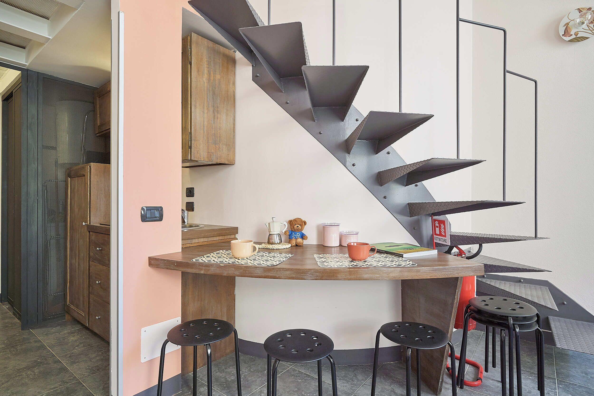 Une cuisine dotée d’un escalier en colimaçon original, d’une machine à café et d’un ours en peluche.