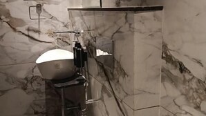Un baño con inodoro, lavamanos y espejo.