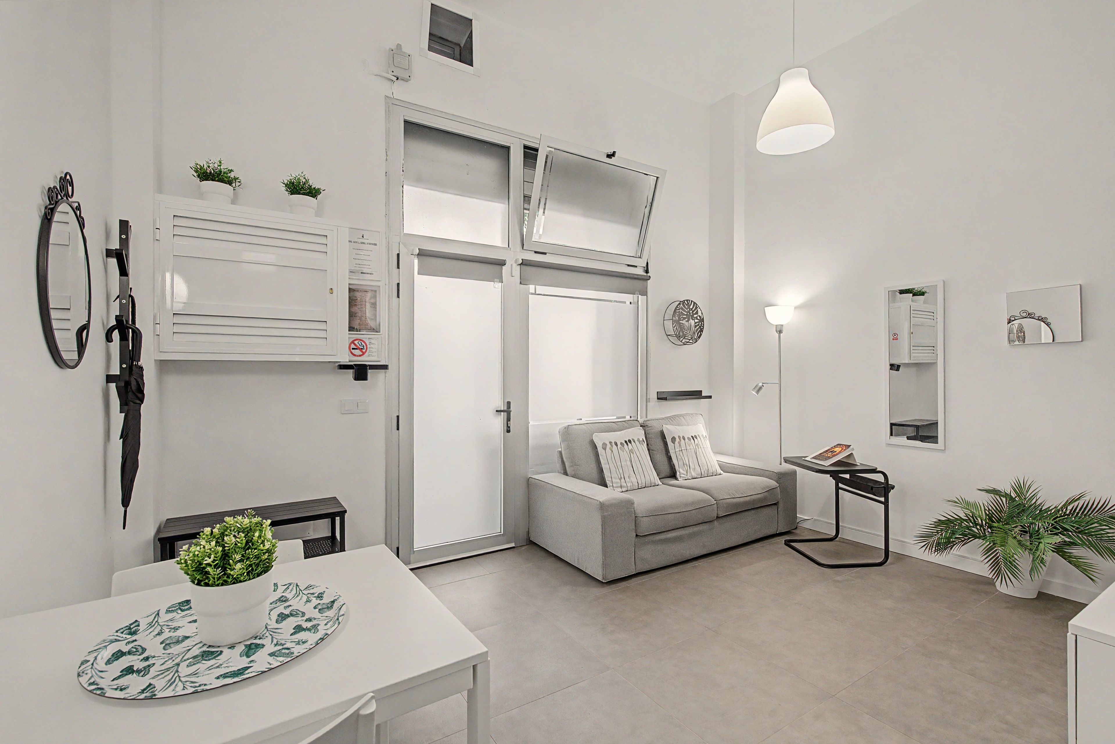 Un salon minimaliste avec un canapé, une table à manger et une suspension.