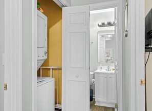 A bathroom with a white door, a white vanity with a mirror, and a toilet. - Tico Taco ya ya ya in Ocean Lakes Campground- golf cart + linens included (Myrtle Beach)
