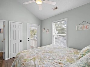 A bedroom with a bed, a ceiling fan, a window with blinds, and a door. - Tico Taco ya ya ya in Ocean Lakes Campground- golf cart + linens included (Myrtle Beach)