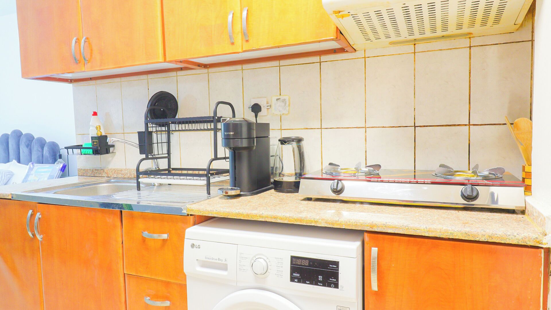 Une cuisine compacte équipée d’un lave-vaisselle, d’une machine à café et d’une cuisinière.