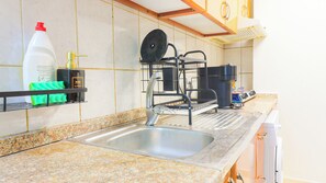Une cuisine dotée d’un plan de travail en granit, d’un évier en acier inoxydable et d’un égouttoir à vaisselle.