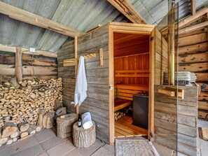 Uma sala de sauna com paredes de madeira, um banco e uma toalha pendurada na parede.