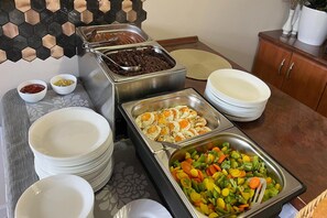 Montaje de bufé con diversos alimentos y vajilla.