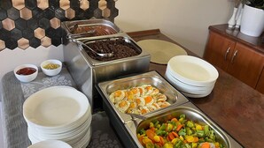 Een buffetopstelling met diverse gerechten en bestek.