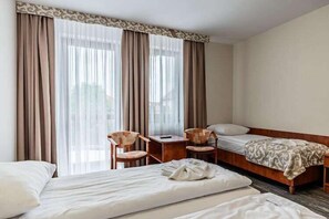 A hotel room with two beds, a desk, and two chairs. - Apartment for 3 people with garden, Rewal (Rewal)