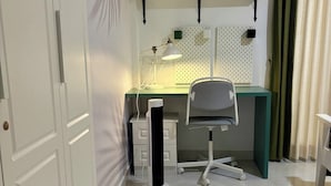 Et moderne kontorrum med et skrivebord, en stol og en bordventilator.