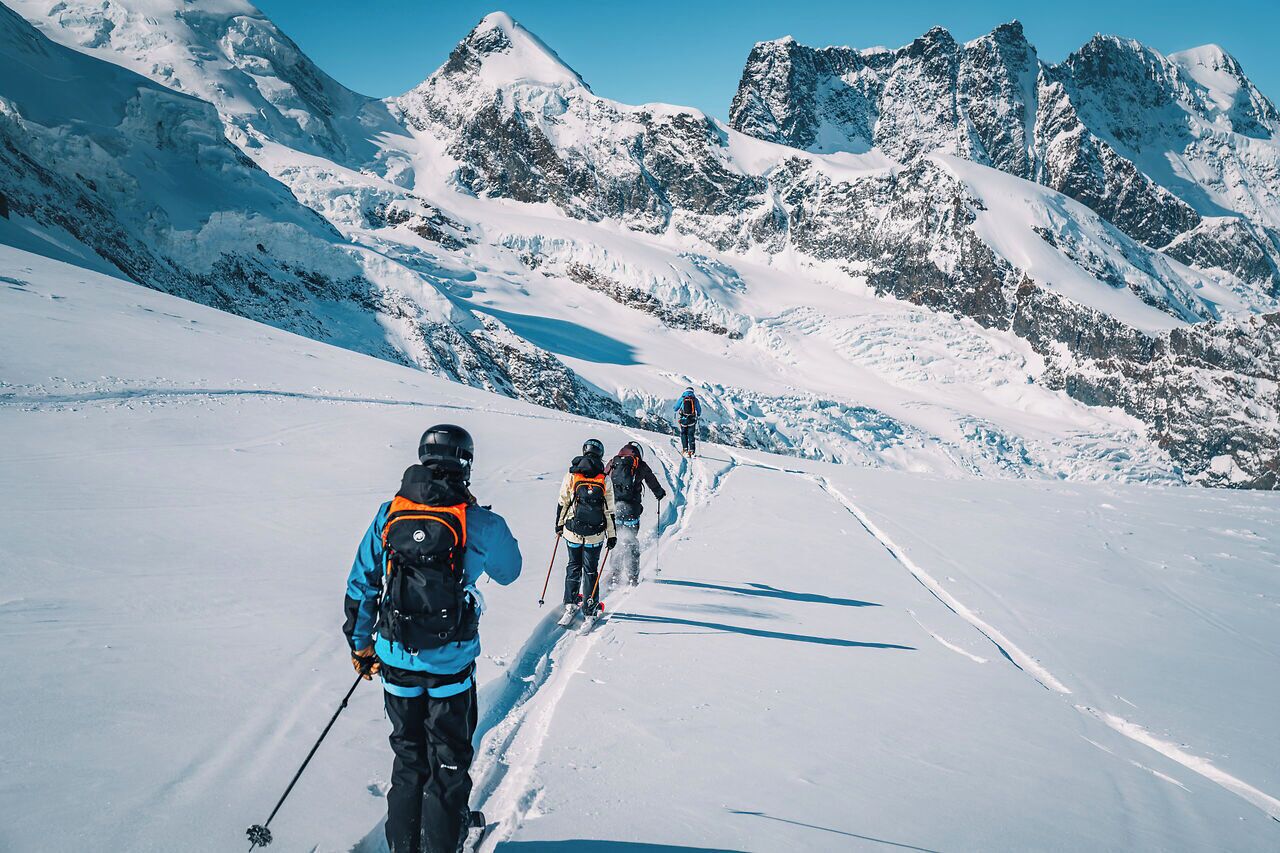 A snowy mountain path with skiers.