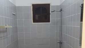 Un baño pequeño con inodoro, lavamanos y ducha.