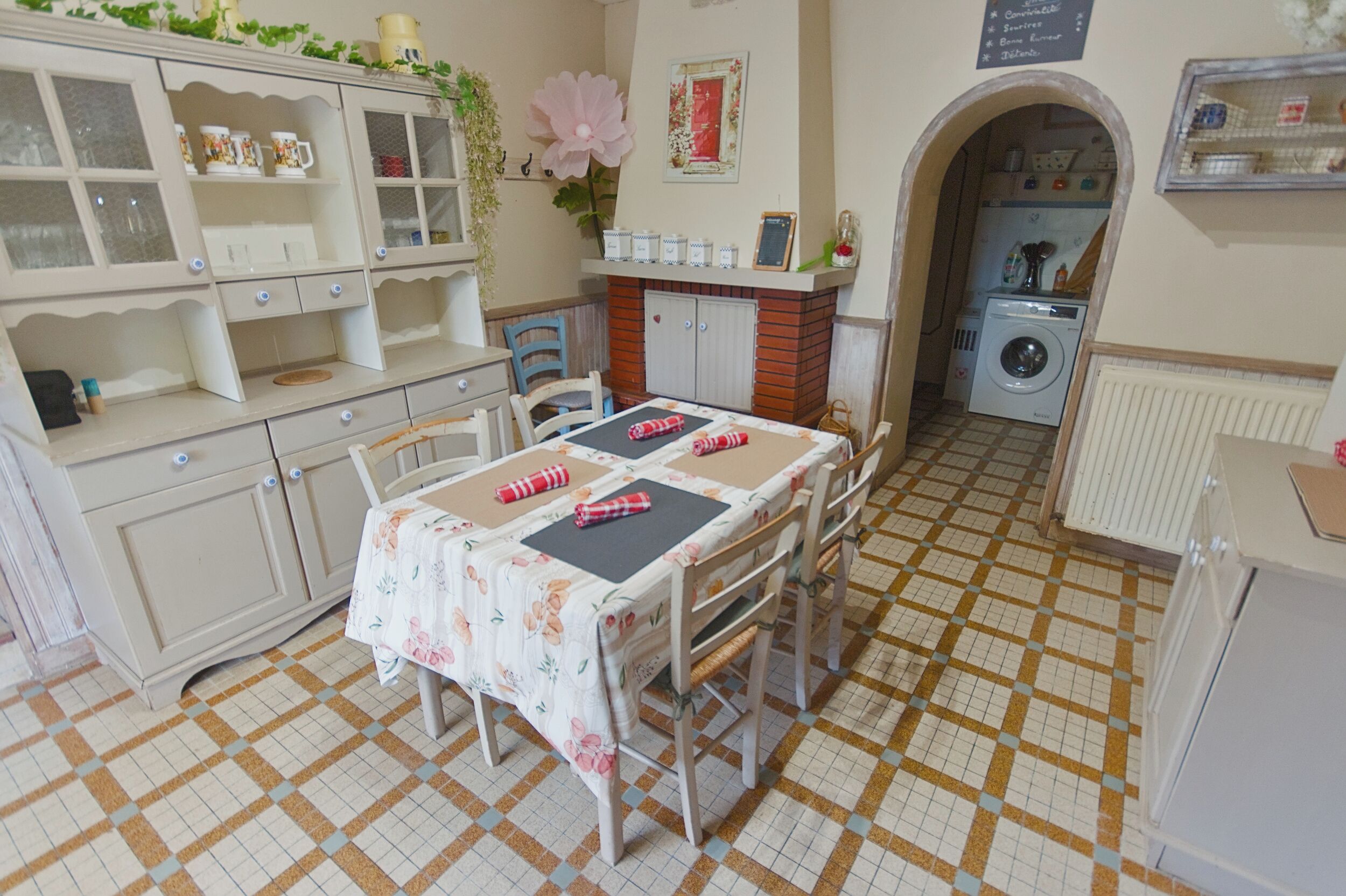A kitchen with a dining table, chairs, a washing machine, and a radiator.