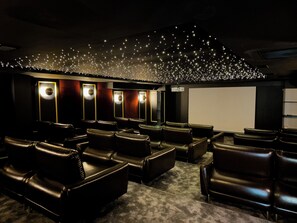 A cinema with leather seating, a large screen, and a ceiling decorated with lights. - Qoople Excellence B17 - Cozy 1-bedroom apartment in Alanya (Alanya)