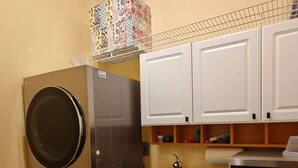A compact kitchen with a built-in washer and dryer, a microwave, and a sink.