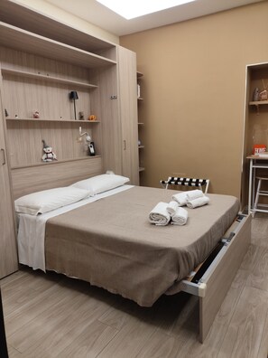 Habitación de hotel con cama, armario y escritorio.