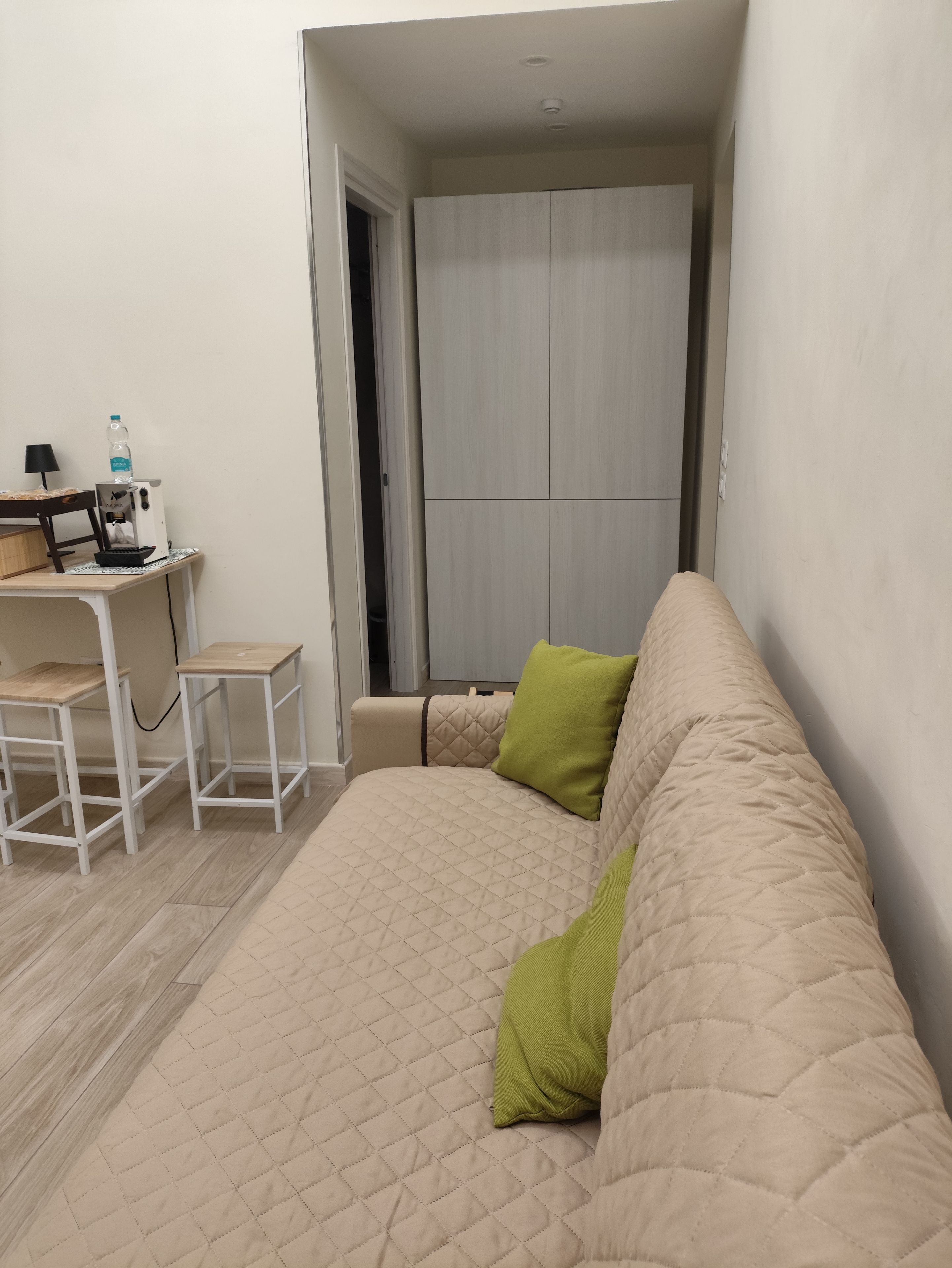 A bedroom with a bed, a desk, and a wardrobe.