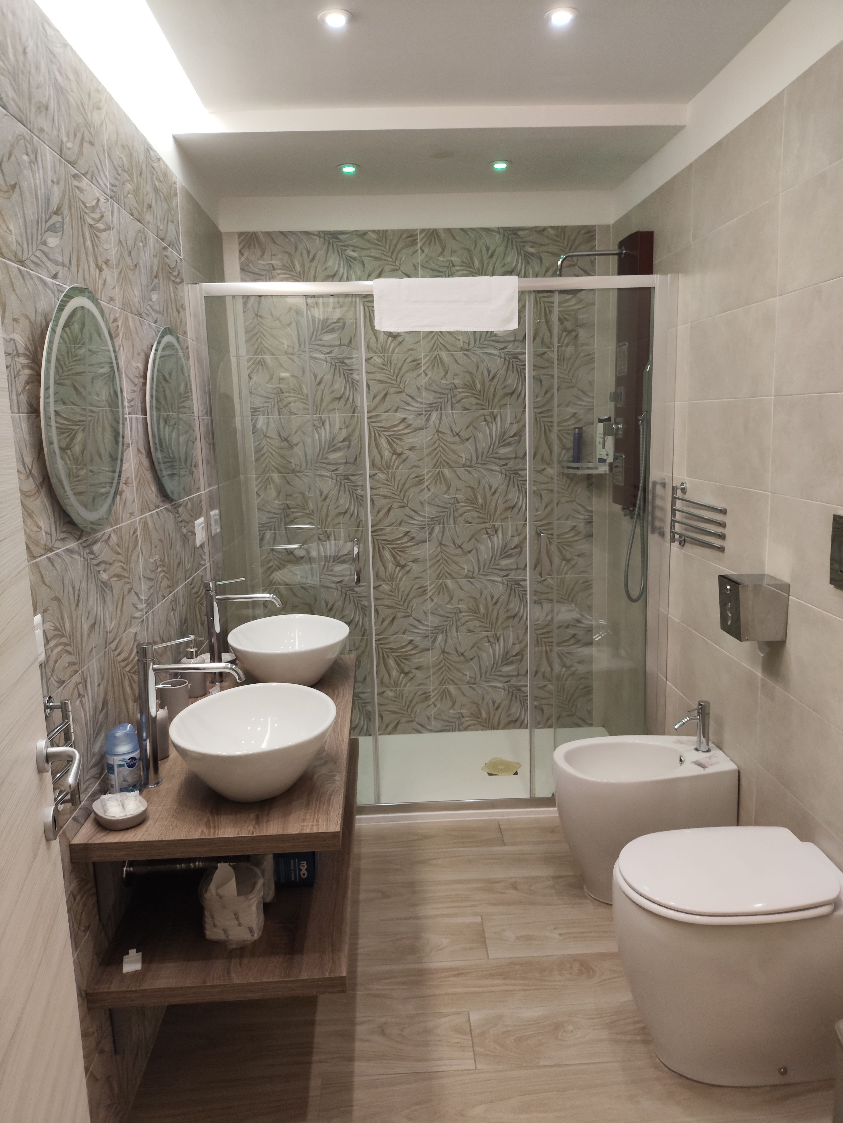 Ein modernes Badezimmer mit zwei Waschbecken, einer Toilette und einer Duschkabine.