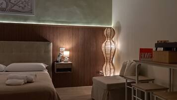 Ein Hotelzimmer mit Bett, Nachttisch, Lampe und einer Wanddekoration.