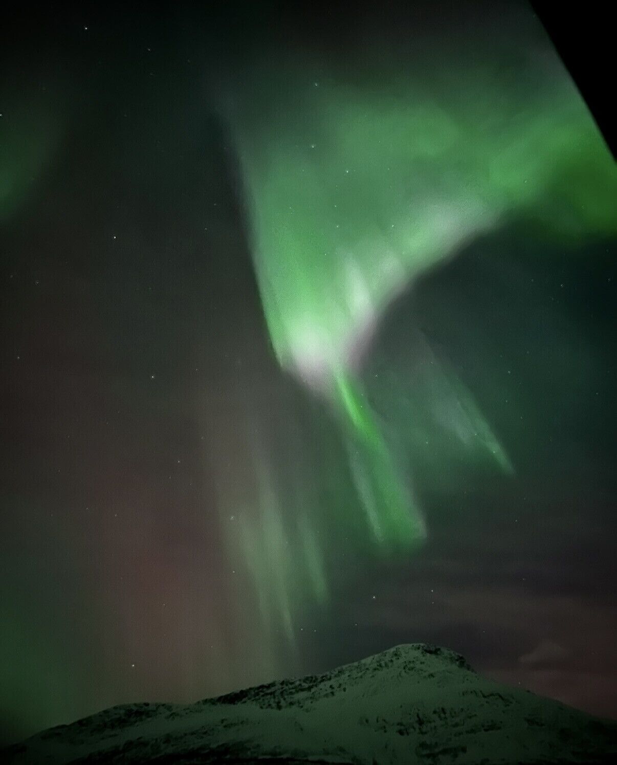 A snowy landscape with a view of the night sky.